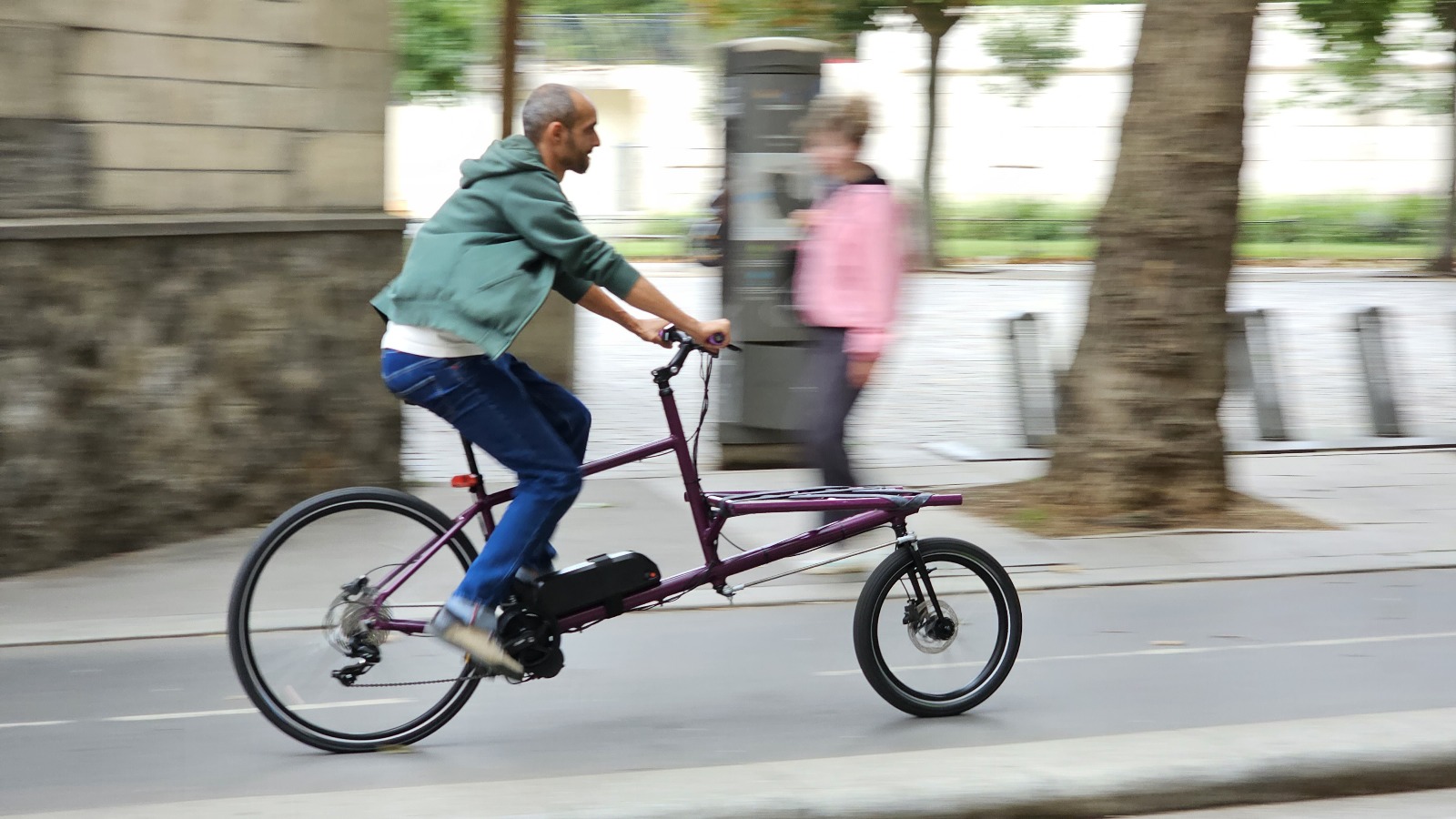 Cyclist on an electric cargo bike in town.