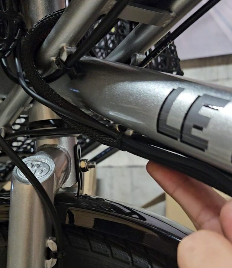 Gaine tressée et câbles fixés sous le tube diagonal avec des colliers